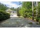 Long gravel driveway leads to this home with a three-car garage and lush landscaping at 754 Olde Thompson Creek Ct Rd, Apex, NC 27523