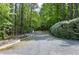 View of a gravel driveway leading up to a home, surrounded by mature trees and garden area at 754 Olde Thompson Creek Ct Rd, Apex, NC 27523