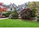 Charming two-story home with a lush green lawn, bench seating, and mature trees surrounding the property at 754 Olde Thompson Creek Ct Rd, Apex, NC 27523