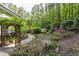 Beautiful backyard garden featuring a stone pathway, bird bath, lush plantings, and mature trees at 754 Olde Thompson Creek Ct Rd, Apex, NC 27523