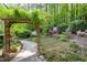 Charming garden featuring a vine-covered arbor, flower beds, stone pathway and mature plantings at 754 Olde Thompson Creek Ct Rd, Apex, NC 27523