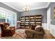 Comfortable living room with bookshelves, a cozy chair, and ample natural light, ideal for reading at 754 Olde Thompson Creek Ct Rd, Apex, NC 27523