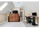 Cozy office space featuring built-in media center, desk, and neutral carpet in a room with sloped ceilings and a skylight at 754 Olde Thompson Creek Ct Rd, Apex, NC 27523