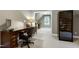 Well-lit home office with a large wooden desk, a wine cooler, and views into an adjacent room at 754 Olde Thompson Creek Ct Rd, Apex, NC 27523