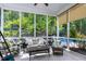 Inviting screened porch with comfortable seating and views of the wooded backyard and swimming pool at 754 Olde Thompson Creek Ct Rd, Apex, NC 27523