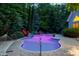 Illuminated in-ground swimming pool with natural rock features, a nearby hammock, and lush landscaping at 754 Olde Thompson Creek Ct Rd, Apex, NC 27523