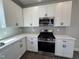 This kitchen features stainless steel appliances, gray backsplash, white cabinets, and quartz countertop at 773 Portland Rose Dr, Knightdale, NC 27545