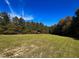 A large open green field, ideal for recreation or building, surrounded by beautiful mature trees at 79 Mildred Dr, Broadway, NC 27505
