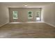Open living room filled with natural light through large windows and wood-look flooring, leading to the yard at 79 Mildred Dr, Broadway, NC 27505