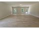 Bright, open living room featuring wood-look flooring, large windows, and a walk-out to the yard at 79 Mildred Dr, Broadway, NC 27505