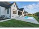 Backyard view with a swimming pool, green lawn, and elegant white-brick home at 833 Dunleigh Dr, Burlington, NC 27215
