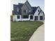 Charming two-story modern home with gray and white painted brick, a manicured lawn, and an inviting curved driveway at 833 Dunleigh Dr, Burlington, NC 27215
