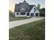 Stunning two-story modern home with gray and white painted brick, a two-car garage, and an inviting curved driveway at 833 Dunleigh Dr, Burlington, NC 27215