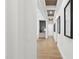 Bright hallway with wood floors and modern decor leads to a stylish entryway with a mirror at 833 Dunleigh Dr, Burlington, NC 27215