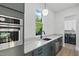 Contemporary laundry area with stainless steel sink, countertop, appliances, and bright natural light at 833 Dunleigh Dr, Burlington, NC 27215