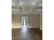 Bright living room with hardwood floors, modern lighting fixture, and a view of the front door at 833 Dunleigh Dr, Burlington, NC 27215