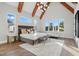 Bright main bedroom featuring vaulted ceilings, exposed beams, large windows, and a seating area at 833 Dunleigh Dr, Burlington, NC 27215