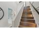 Staircase with wooden steps with a white accent wall leading to a bathroom and bedrooms at 833 Dunleigh Dr, Burlington, NC 27215