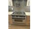 Close-up of a stainless steel Zline gas range stove with a stylish herringbone backsplash at 833 Dunleigh Dr, Burlington, NC 27215