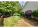 Landscaped backyard with lawn, trees, and shrubs at 8437 Whisper Ridge Pl, Raleigh, NC 27613