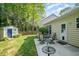 The backyard showcases a cozy patio with a dining set next to a storage shed, offering outdoor relaxation at 8437 Whisper Ridge Pl, Raleigh, NC 27613