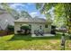 Backyard view showcasing a well-maintained lawn and patio area with a dining set and grill at 8437 Whisper Ridge Pl, Raleigh, NC 27613
