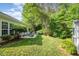 Expansive backyard featuring lush greenery and a patio with an outdoor dining set, perfect for entertaining at 8437 Whisper Ridge Pl, Raleigh, NC 27613