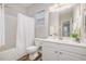 Bathroom featuring a tub with a shower, white vanity, and decorative accents at 8437 Whisper Ridge Pl, Raleigh, NC 27613