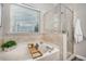 Bathroom showcasing a tub, glass-enclosed shower and tiled walls and flooring at 8437 Whisper Ridge Pl, Raleigh, NC 27613