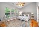 Bright bedroom with large windows, ceiling fan, and decorative area rug at 8437 Whisper Ridge Pl, Raleigh, NC 27613