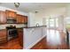Open kitchen with stainless appliances, wood cabinets, granite countertops, and breakfast bar at 95 Lockhaven Ct, Cameron, NC 28326