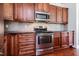 Updated kitchen showcases stainless steel appliances, rich wood cabinets, and dark granite countertops at 95 Lockhaven Ct, Cameron, NC 28326