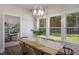 An elegantly lit dining room features a wooden table, a decorative light fixture, and large windows overlooking a lush landscape at 1038 Beacon Hill Rd # 46, Lillington, NC 27546