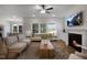 Open living room with fireplace, TV, and large windows that flood the space with natural light at 1038 Beacon Hill Rd # 46, Lillington, NC 27546