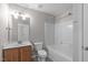 Neutral bathroom features a wood vanity with an integral sink and a white tub and shower combination at 104 Harvolly Dr, Holly Springs, NC 27540