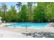Large community pool with multiple access points on a sunny day with trees lining the exterior at 104 Harvolly Dr, Holly Springs, NC 27540