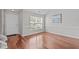 Light filled entryway features gleaming hardwood floors, a front door with sidelight and transom, and neutral colored walls at 104 Harvolly Dr, Holly Springs, NC 27540