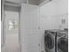 Convenient laundry room features stainless steel washer and dryer units next to the hallway at 104 Harvolly Dr, Holly Springs, NC 27540