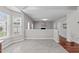 Bright, open-concept living space showcasing tile flooring, a window bay and a view of a fireplace with built-in shelving at 104 Harvolly Dr, Holly Springs, NC 27540