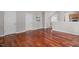 Spacious room featuring hardwood floors and neutral walls with a doorway leading into kitchen and a view of the stairway at 104 Harvolly Dr, Holly Springs, NC 27540