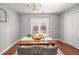 Well-lit dining room with chandelier, table set for meal, and french doors to backyard at 104 Old Cooper Sq # Bldg J 3, Chapel Hill, NC 27517