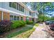 View of the townhome exteriors with brick accents, shutters, and landscaped green space at 104 Old Cooper Sq # Bldg J 3, Chapel Hill, NC 27517