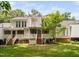 The back of the house features a screened porch, deck, patio and a manicured lawn at 104 Planetree Ln, Cary, NC 27511