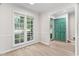 Bright living room featuring large windows, a green door, and stylish floors at 104 Planetree Ln, Cary, NC 27511