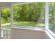 Screened porch view of backyard featuring well-manicured lawn surrounded by lush trees at 104 Planetree Ln, Cary, NC 27511