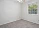 A bright bedroom featuring a large window and neutral-toned carpeting, and a ceiling fan at 104 Sir Richard Ln, Chapel Hill, NC 27517