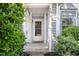 Close up of front door, sidelight and the house number, nestled within lush landscaping at 104 Sir Richard Ln, Chapel Hill, NC 27517