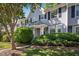 Charming townhome with light gray siding, black shutters, and neatly manicured landscaping in front at 104 Sir Richard Ln, Chapel Hill, NC 27517