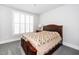 Cozy bedroom with a wood bed frame, a quilt, and a window with white shutters at 10530 Sablewood Dr # 112, Raleigh, NC 27617