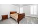Neutral bedroom with light gray carpet, wooden furnishings, and shuttered windows at 10530 Sablewood Dr # 112, Raleigh, NC 27617